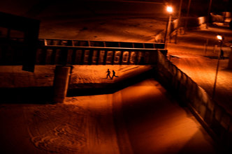 Paolo Pellegrin, Two men who attempted to enter the U.S. illegally run across the dry Rio Grande riverbed back to Ciudad Juárez, Mexico, after being spotted by the U.S. Border Patrol. El Paso, Texas, USA 2011, © PAOLO PELLEGRIN/MAGNUM PHOTOS