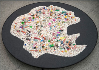 Map Office, Moving Lemuria from the Indian to the Pacific Ocean, 2017, Sanibel Island shells, plastic waste collected on the beach, fine white sand, plywood, 300 × 200 × 30 cm. Collection of the artist, © mapoffice