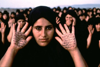 Shirin Neshat, Rapture Series (Women with Writing on Hands), 1999, Chromogenic color print, 40 ½ x 60 ¼ inches, Edition of 5 + 2AP. New Orleans Museum of Art, Museum purchase, 2001.292, © Shirin Neshat, Courtesy Galerie Jérôme de Noirmon-Paris