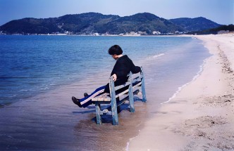 Shimabuku, Assis sur la vague, 1998 - C-Print mounted on aluminum, 70x105 cm, Edition of 5, © Shimabuku, Courtesy of the artist and Air de Paris-Romainville