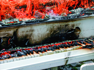 Chiharu Shiota, In Silence, 2002, Installation, burnt piano, burnt chairs, black wool, Akademie Schloss Solitude, Stuttgart, Germany, Digital print, 30 x 40.5 cm, Photo: Sunhi Mang, © Chiharu Shiota, Courtesy the artist and Taipei Fine Arts Museum