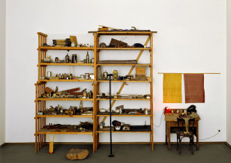 Joseph Beuys, Barraque DʼDull Odde, 1961–1967, 2 workshop shelves with over 650 individual objects, worktop, 1 rubber blanket + 1 gutta-percha cloth on the wall, 3 wooden sculptures in front of the double rack, 290 × 400 × 90 cm, Kunstmuseen Krefeld, gift from the collection of Helga and Walther Lauffs, © VG Bild-Kunst, Bonn 2021, photo: Volker Döhne / Kunstmuseen Krefeld